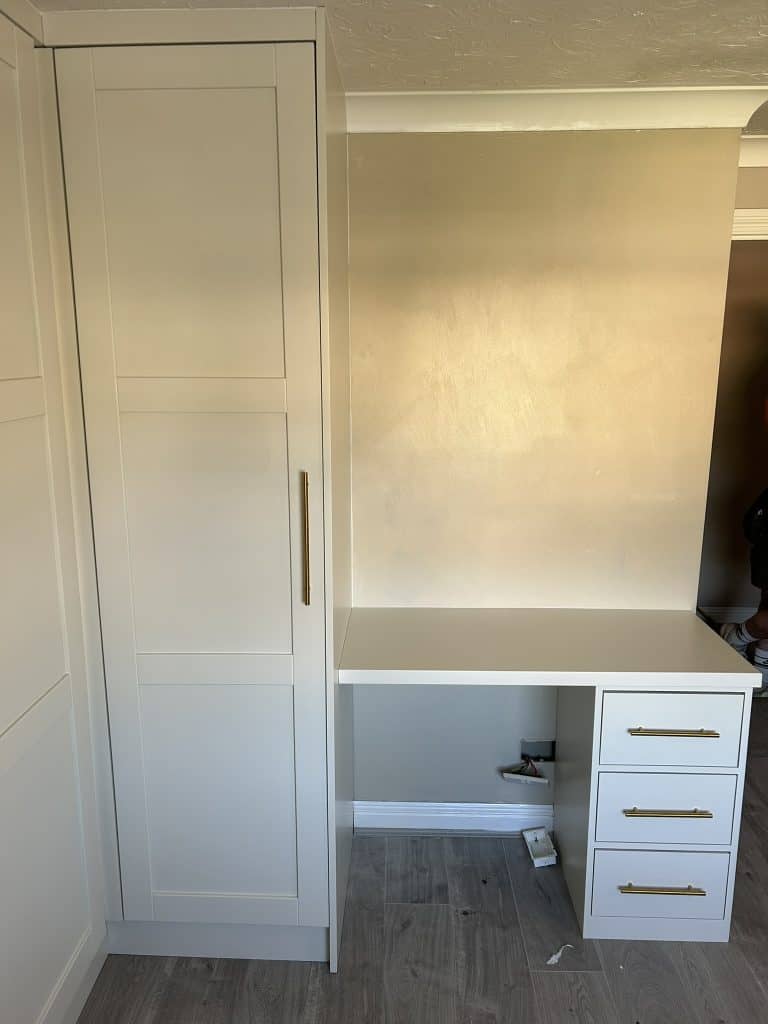 A custom-designed wardrobe that incorporates a sleek desk.